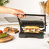 Black electric panini press with open grill plates, shown front-on for product detail