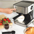Stainless steel espresso coffee machine in use, cup positioned under spout