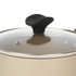 Close-up of glass lid with black handle on beige saucepan