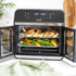 Black Salter air fryer oven on kitchen counter with doors open, showing cooked chicken, chips and vegetables inside