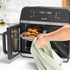 Salter digital air fryer oven with open door, showing tray of cooked chicken wings