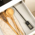 Black cast iron casserole dish on induction hob, soup inside, food thermometer in use