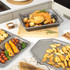 Set of non-stick metal baking trays with British roast foods in modern kitchen