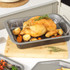 Set of non-stick metal baking trays with British roast foods in modern kitchen