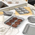 Round non-stick cake pan with baked apple cake on kitchen counter, baking accessories nearby