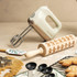 Cream electric hand mixer with beater attachments, shown for home baking