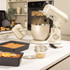 Cream hand mixer on kitchen counter, angled to show chrome whisks and Salter branding