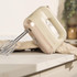 Baking tray and tins with croissants, cookie and hand mixer on kitchen counter
