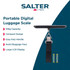 Digital luggage scale with black textured finish and strap on wooden kitchen worktop