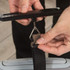 Hand using digital luggage scale to weigh suitcase with attached black strap