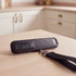 Black digital luggage scale weighing a suitcase, shown in hand