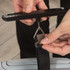 Hand using digital luggage scale to weigh suitcase with attached black strap