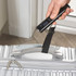 Digital luggage scale weighing silver hard-shell suitcase by the handle