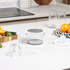 Egg separator on counter with broken eggshells, carton of eggs, and flour bag nearby