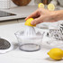Glass measuring jug with fresh orange juice and sliced oranges on wooden board