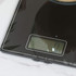 Black digital kitchen scale and wooden utensils in open drawer