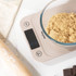 Digital kitchen scale in beige with glass bowl of brown sugar, for baking prep.