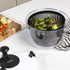Salad spinner with black and white lid, shown on kitchen counter near fresh salad