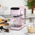 Pink espresso coffee machine on kitchen counter with coffee and croissants nearby