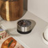 Stainless steel mechanical kitchen timer with black base on shelf