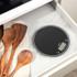 Black digital kitchen scale next to wooden utensils in drawer, product listing.