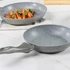 Grey non-stick frying pan with speckled finish, shown on kitchen surface