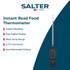 Digital meat thermometer checking temperature in cooked ham on kitchen worktop