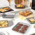 Assorted non-stick silver baking trays and racks in kitchen setting