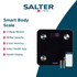 Black digital bathroom scale with silver sensors on tiled floor