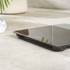 Silver digital bathroom scale with clear display, shown on wooden floor