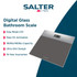 Person standing on digital bathroom scale with glass top, shown from ankle down