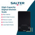 Black digital kitchen scale weighing chocolate pieces, baking accessories visible