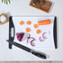 White chopping board with black edges, chef’s knife, sliced carrot and red onion.