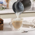 Black Salter milk frother on kitchen counter, shown with coffees and hot chocolate.