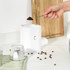 Set of three white kitchen storage tins labelled S, C and T on marble counter