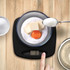 Digital kitchen scale with bowl, showing flour, butter and an egg being weighed