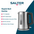 Stainless steel electric kettle pouring hot water into cup on kitchen counter