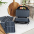 Square waffle maker in black on kitchen worktop, with cooked waffles served