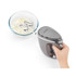 Silver hand mixer whisking cream in glass bowl, shown from above