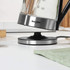 Glass electric kettle pouring water, stainless steel base, Salter brand visible
