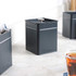 Grey metal tea and coffee canisters with matching kettle pouring hot water into glass mugs