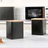 Set of two black metal storage canisters with wooden lids on kitchen worktop
