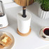Black and wood mug tree with six pegs for cups, shown on kitchen counter.