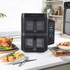 Black double drawer air fryer on kitchen counter with control panel, food served beside.