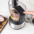 Black and silver food processor with slicing discs on kitchen counter