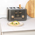 Black bread bin with copper handle and lettering, loaf of bread inside, kitchen worktop