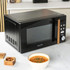 Black Salter microwave with wood-effect handle shown on kitchen counter