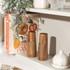 Salt or pepper grinder in hand seasoning chicken breast and couscous salad, modern kitchen setting
