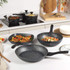 Set of black speckled non-stick cookware with assorted meals, shown from above