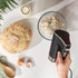 Black electric hand mixer with chrome whisk attachment, side view